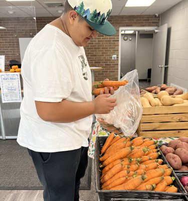 Manuel Pacheco, a member of the Kingston YMCA Youth Crew, helps manage the Winter Farm Stand at the YMCA in Kingston, NY.